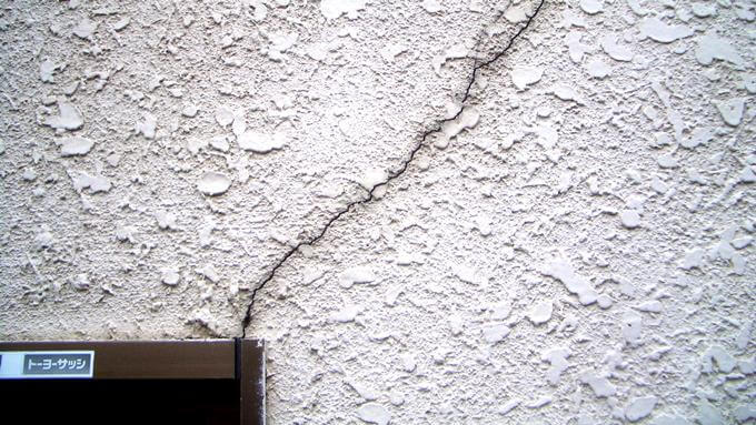 サッシの角からヒビ割れているモルタル外壁