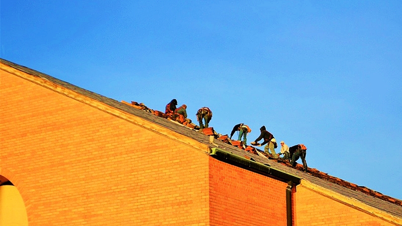 屋根瓦の修理をする職人