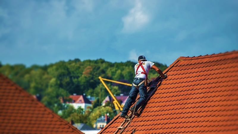 屋根に乗って修理をする職人