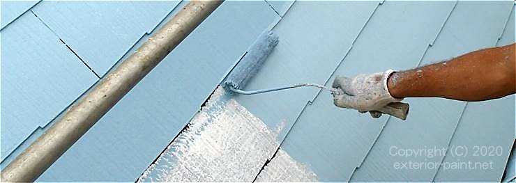 水色の遮熱塗料をローラー塗装中のの屋根